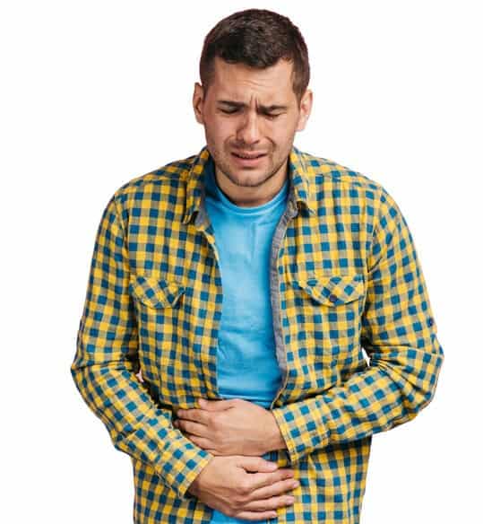A man in a checkered shirt holds his stomach in pain. If a restaurant's hot water is not up to code, diners may be at risk of contracting foodborne illnesses.