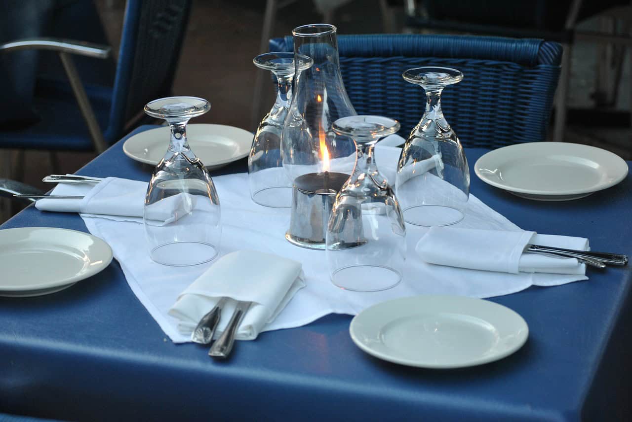 A beautifully set table with a candle in the center shows how hotels can offer unique, high-quality dining experiences.