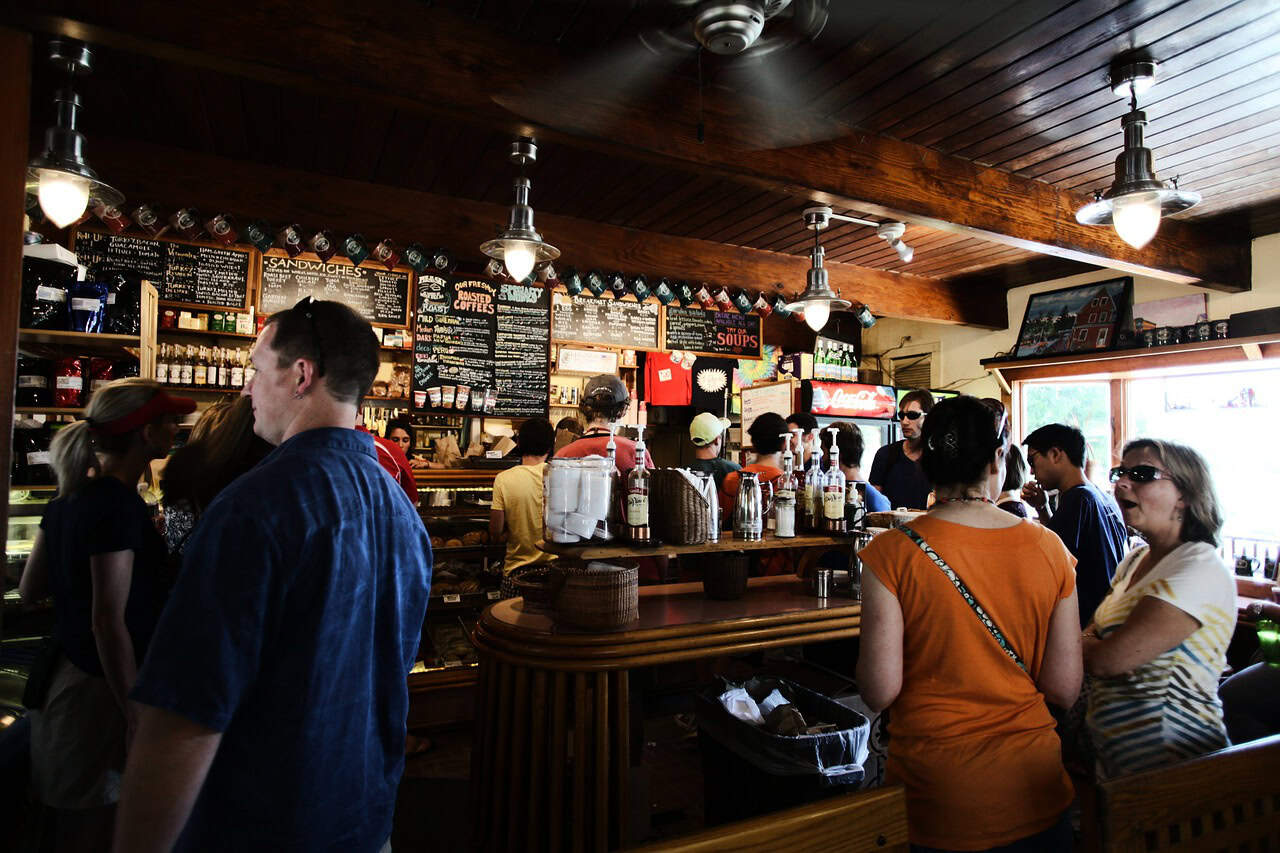 People of all ages enjoy talking with friends while standing at the bar, waiting for a brewery trivia night to start.