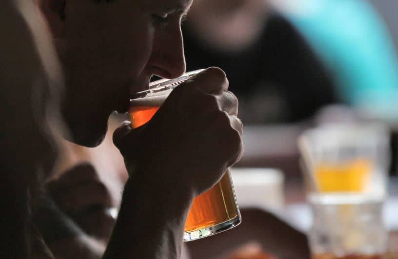 A man drinking an American-style lager beer