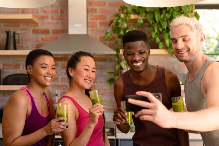 A group of friends enjoy a smoothie taste-test at a gym.