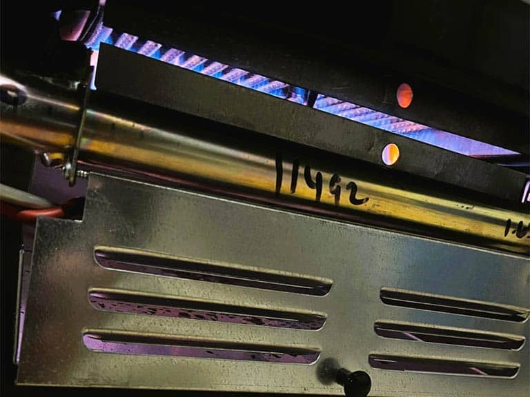 A close up of a lit commercial gas burner is shown.
