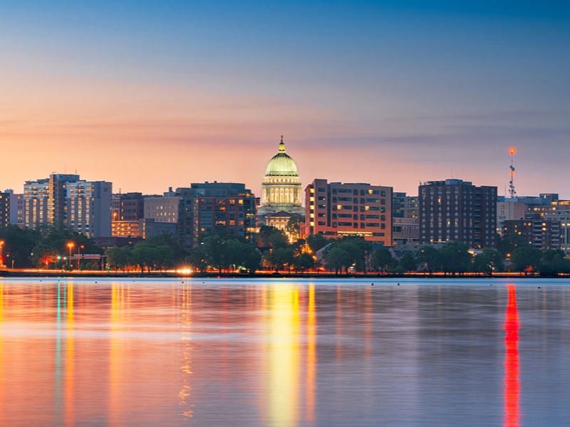 The Wisconsin State Capitol rises over the Madison skyline and Lake Monona
