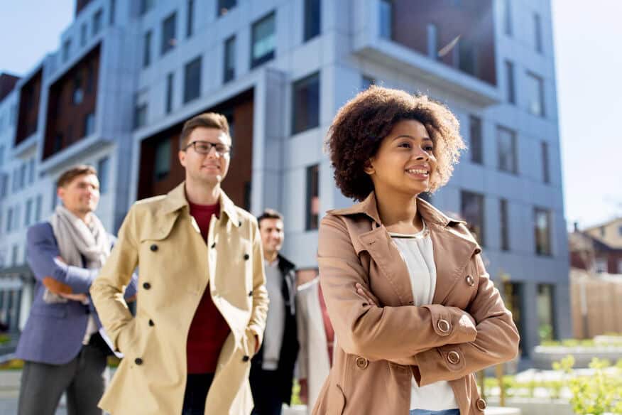 A group of young adults walking in front of an apartment building