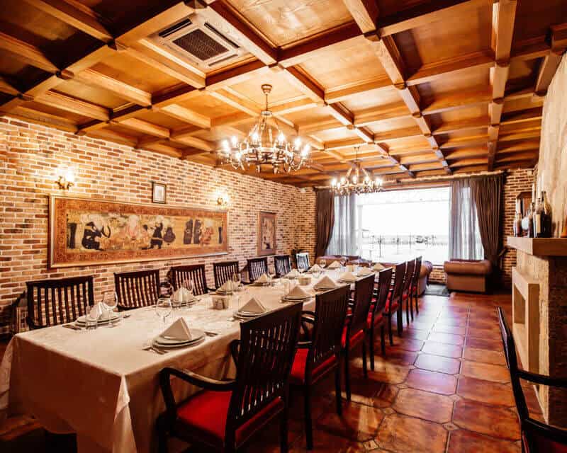 A long table in a restaurant's private room shows different lighting choices, including wall scones and simple chandeliers. 