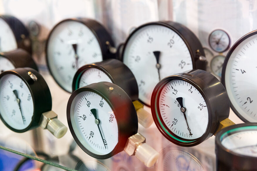 A close-up of many circular pressure gauges lying on a shelf. Correct pressure readings are essential boiler safety features. 