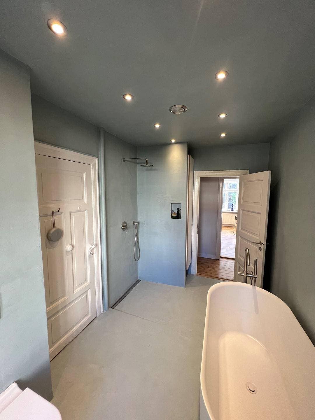  Ny badeværelse med ny bruser og fritstående badekar i hvid.