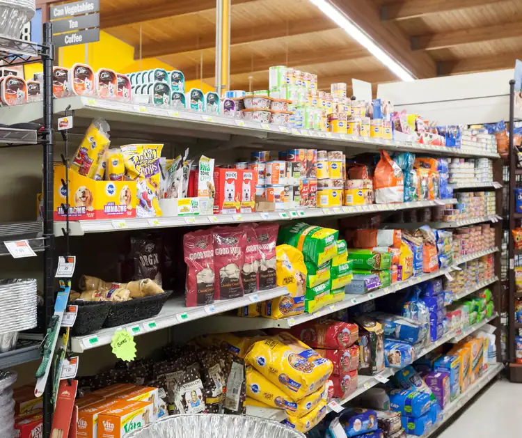 Pet food products on store shelves for dogs and cats.