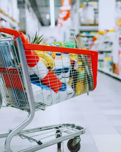 Cleaning supplies shopping cart in a retail store aisle.
