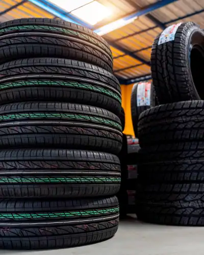 Tires stacked in a warehouse for industrial and automotive use.