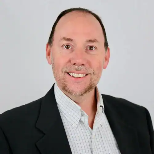 Professional team member smiling in business attire for Revology Analytics.