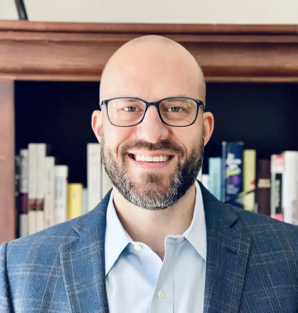 Professional team member at Revology Analytics smiling in office.