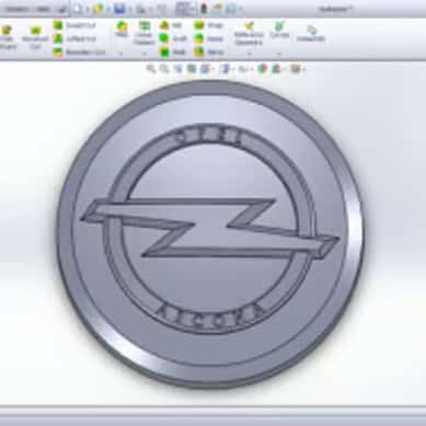 Rundt metalemne med indgraveret logo i relief - "ASCONA"