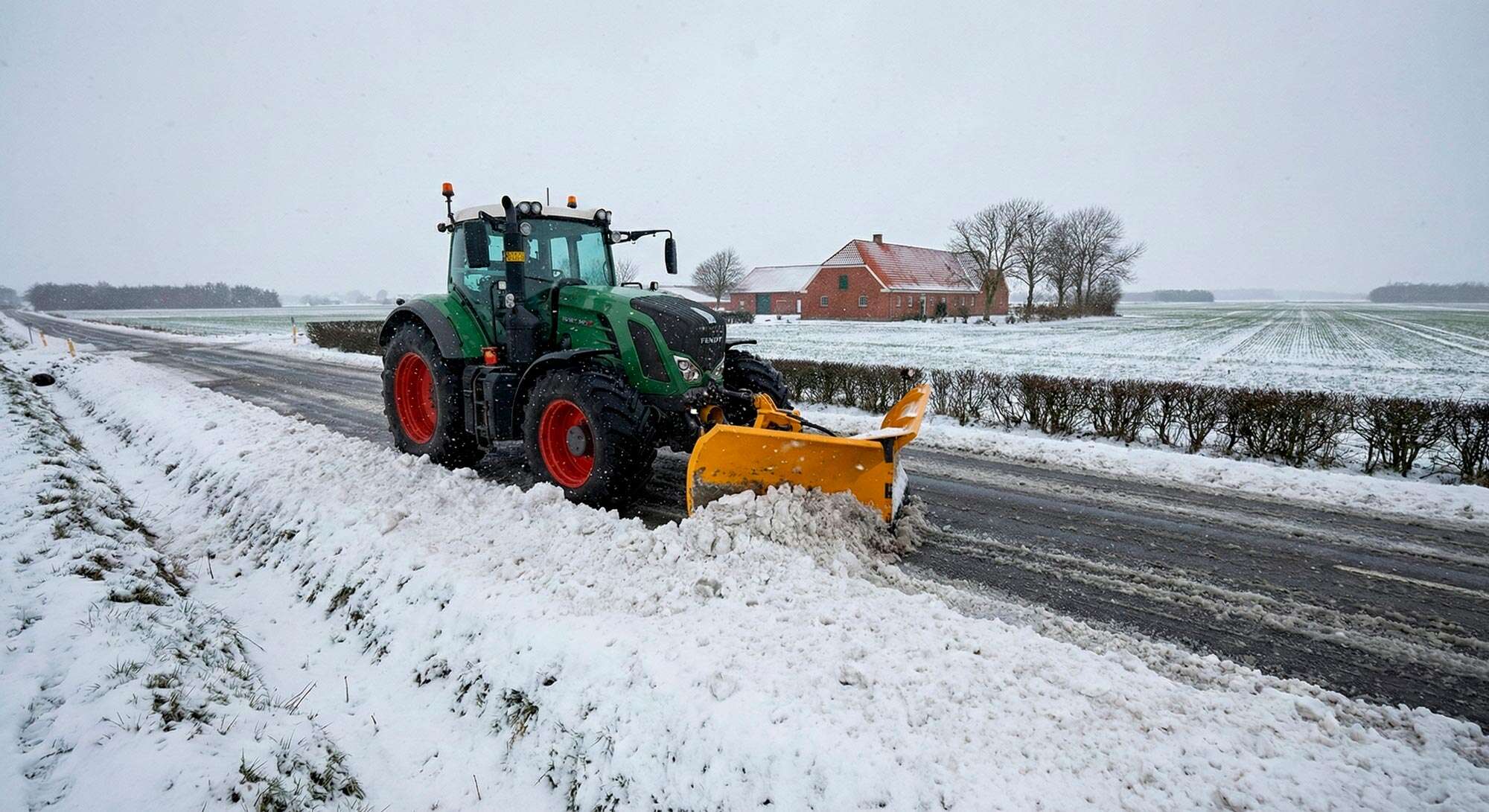 Traktor i gang med snerydning på landevej