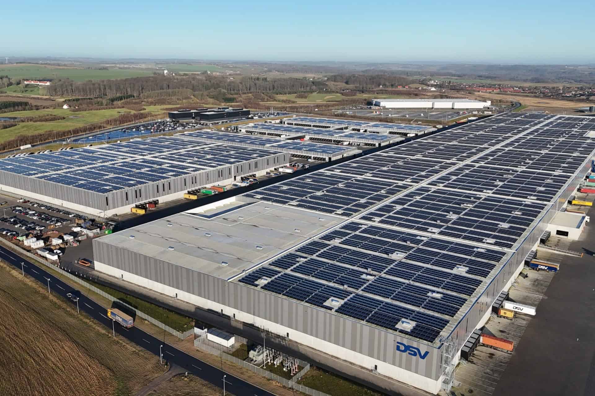 Stort solcelleanlæg på lagerbygning for bæredygtig energiproduktion.