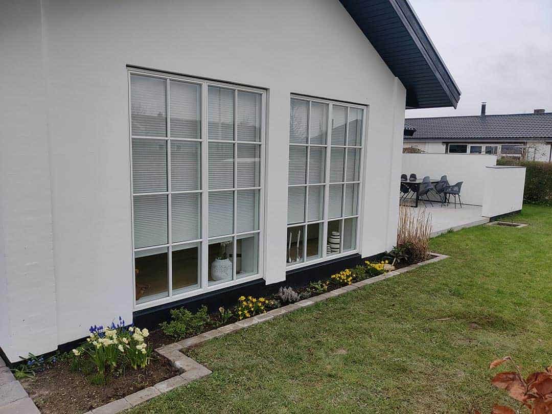Færdigt resultat af nyanlæg af have og belægning i Køge ved hvid villa.