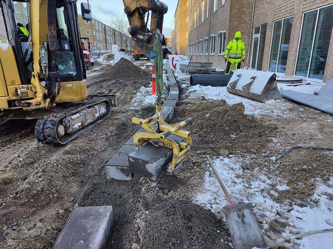 Professionel brolægning på Sjælland med maskinel hjælp til tunge løft af sten.
