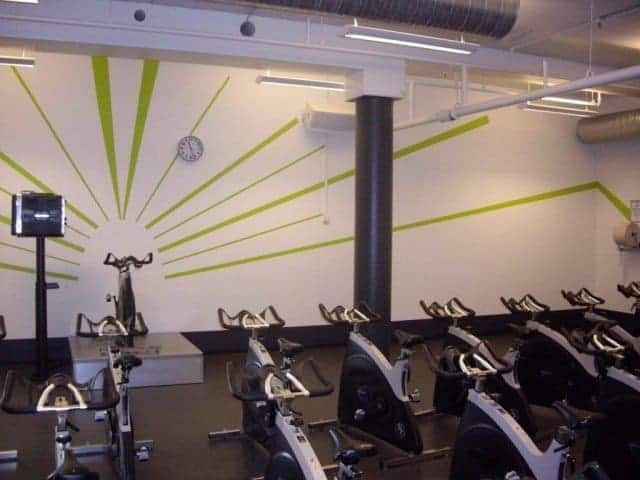 Præcise grønne linjer malet på hvid væg til holdundervisning i fitness center