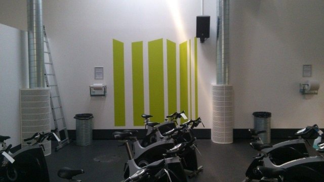 Hvid væg med grønne søjler i fitness center