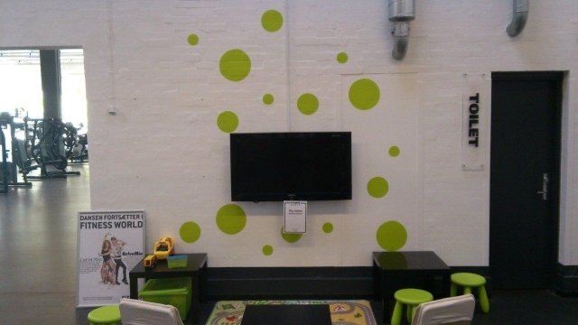 Hvid væg med grønne cirkler i fitness center