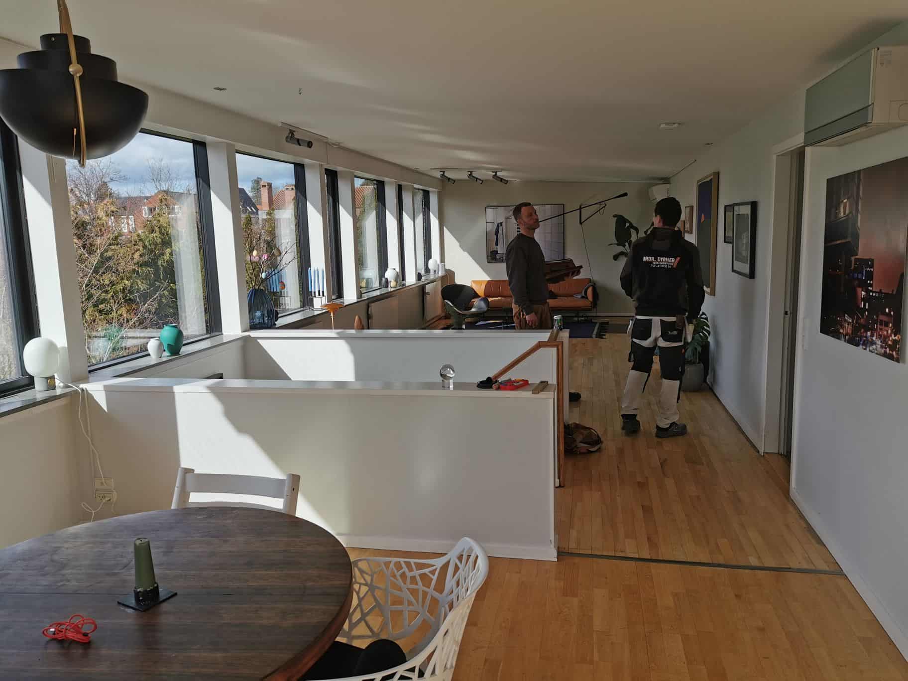 Professionelle malere i gang med indendørs malerarbejde.