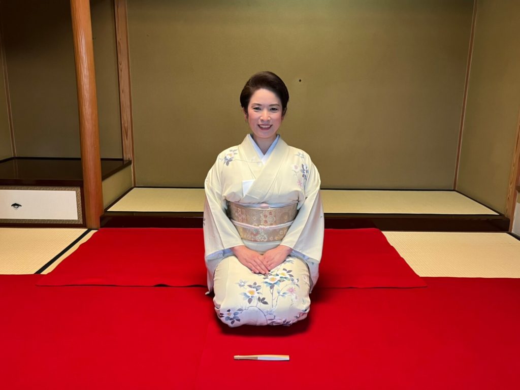 Elegant woman in traditional kimono performing shamisen sitting on tatami mat at Shinjuku Nagauta Shamisen School.