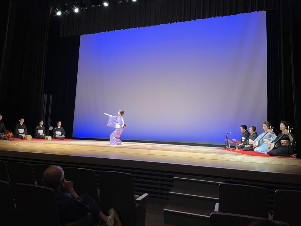 Traditional shamisen performance during a Shinjuku Nagauta Shamisen class; performers dressed in kimono seated on stage.