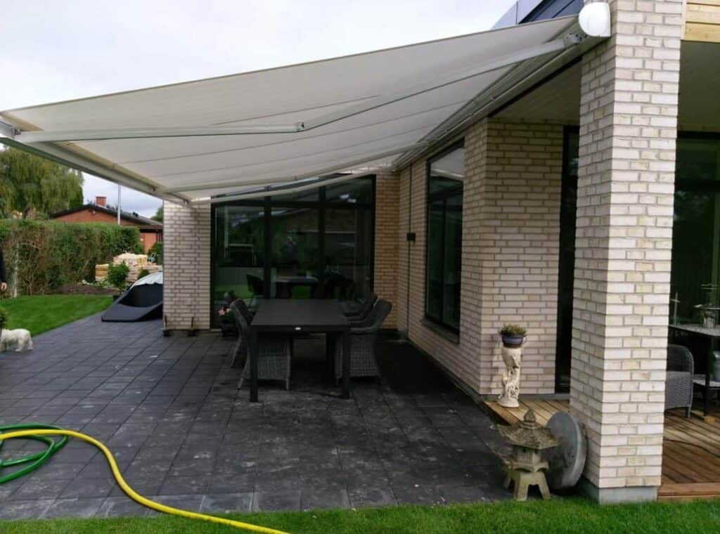 Hvid markise over fliseterrasse