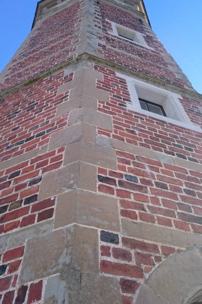 Detalje af mønstret murværk på kanten af en bygning.