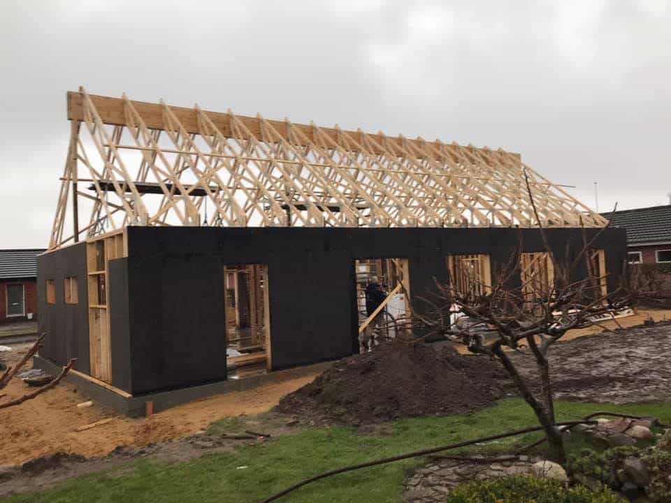 Facade på sort træhus med nyrejst tagkonstruktion