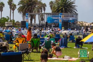 A crowd on picnic blankets and lawn chairs enjoys the Oxnard Jazz Festival