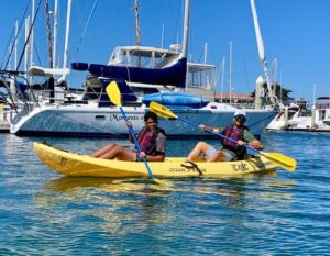 A pair paddling a kayak in the harbor