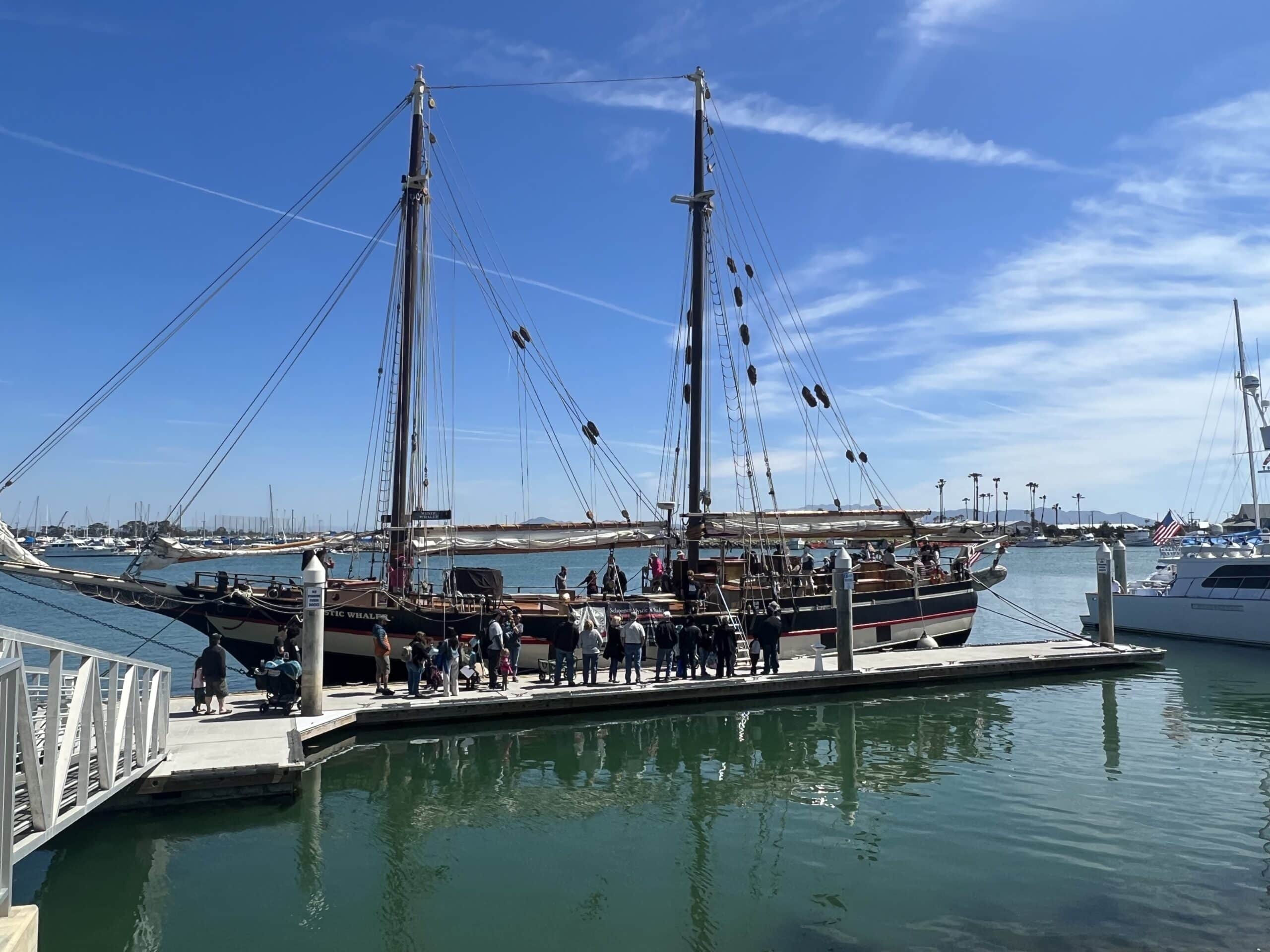 Historic Mystic Whaler sailing ship docked at Channel Islands Harbor with visitors on deck.