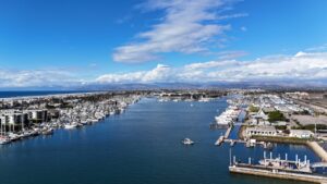 Aerial view of Channel Islands Harbor with boats and marina facilities under a partly cloudy sky.