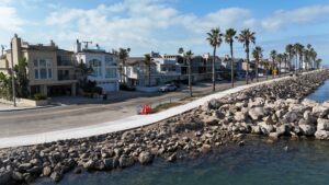 Beautiful waterfront homes at Channel Islands Harbor with palm trees and rocky shoreline.