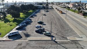 An aerial view of the Channel Islands Harbor parking lot with cars and surrounding greenery.