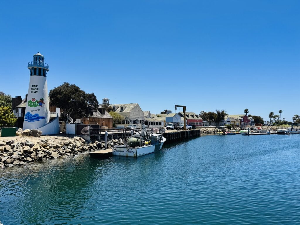 Scenic view of Channel Islands Harbor with lighthouse and boats on a sunny day.
