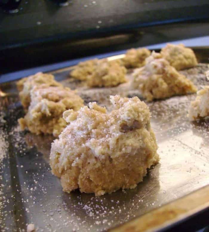 Image shows a close up of an uncooked ball of cookie dough on a cookie sheet