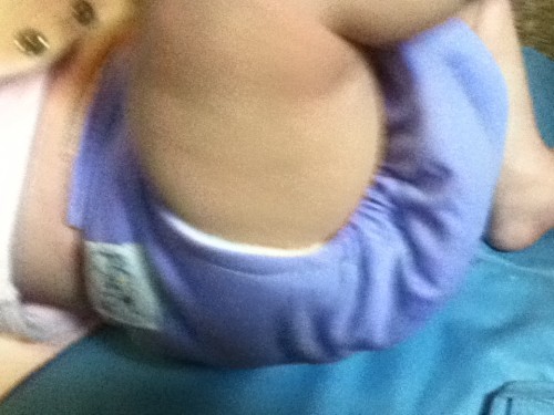Image shows a close up of an infants leg to show fit of cloth diaper