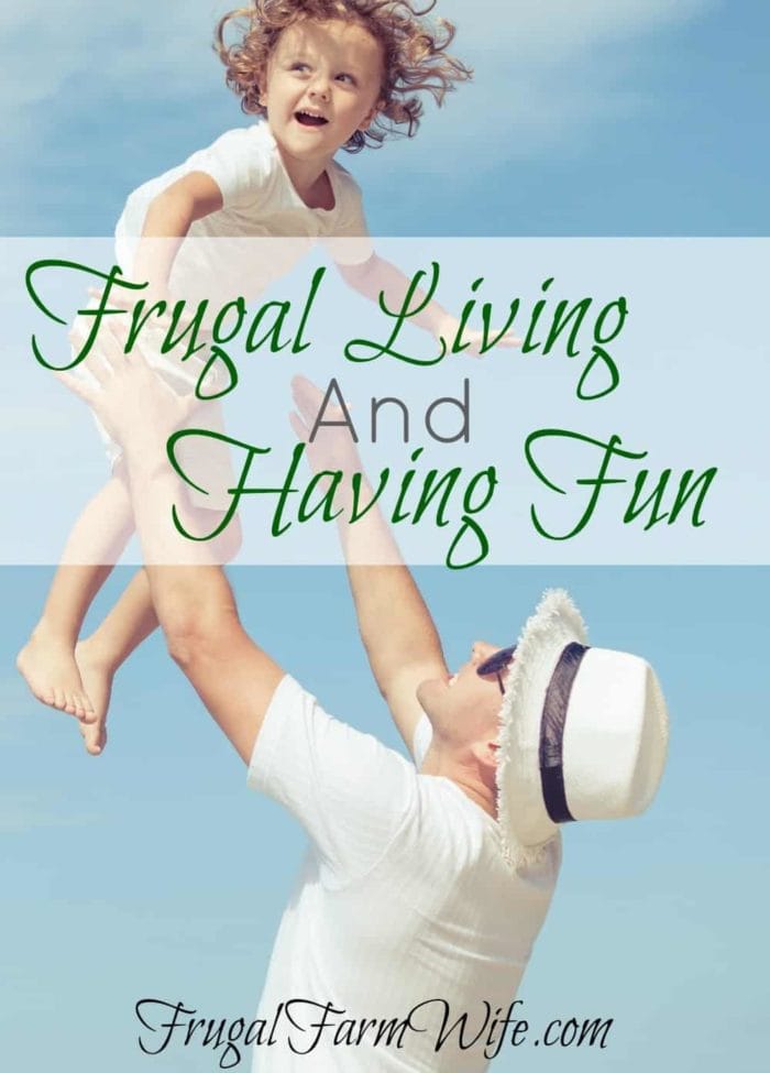 Image shows a man holding a small child in the air with text that reads "Frugal Living and Having Fun"