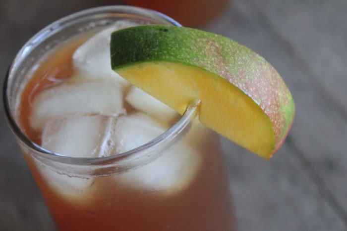 Photo shows a glass of mango iced tea from above