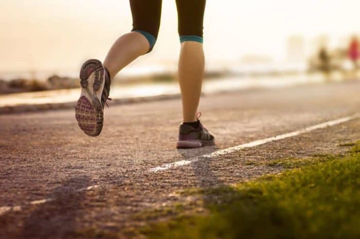 Image shows the legs of a person running on a road