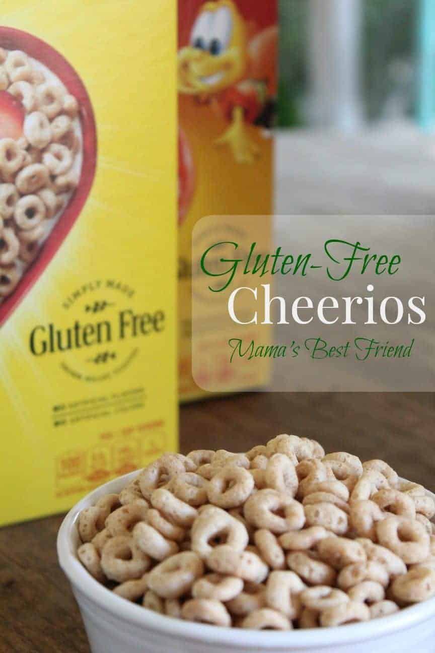 Image shows a large box of Cheerios behind a large bowl of Cheerieos with text overlay that reads "Gluten-Free Cheerios Mama's Best Friend"