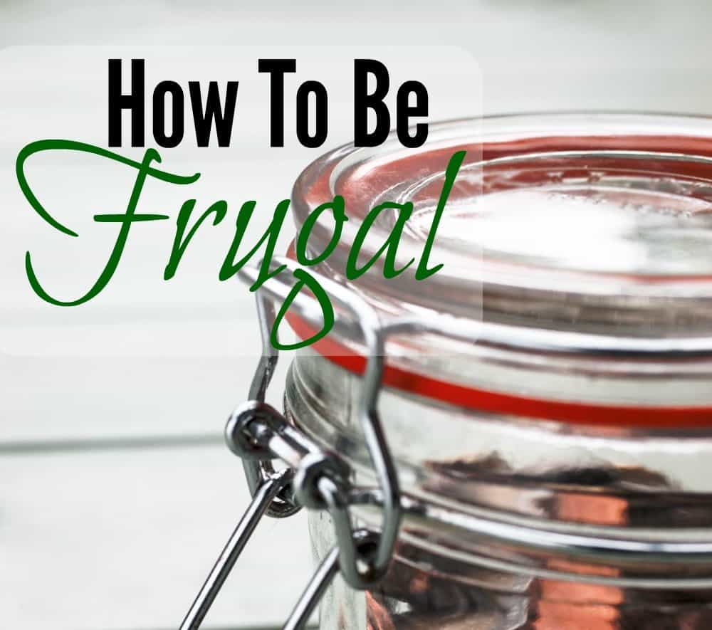 Image shows a close up photo of a glass jar full of coins, with text overlay that reads "How to be frugal: