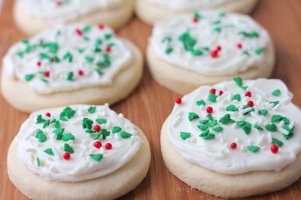 Photo shows rows of sugar cookies with white frosting and red and green decorations