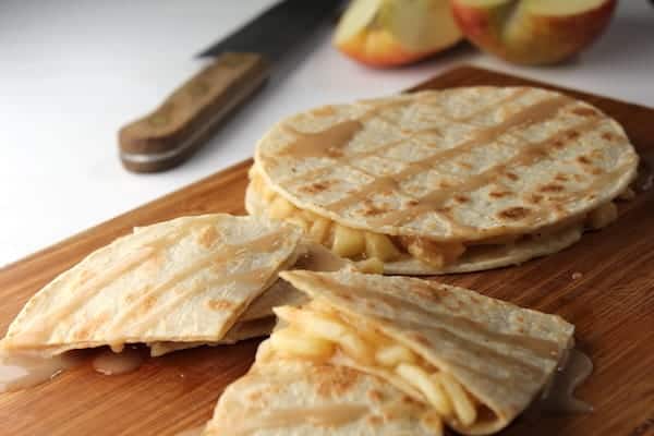 Image shows apple pie quesadillas on a cutting board