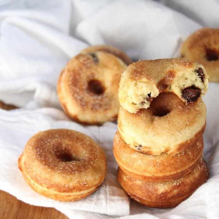 Photo shows a stack of doughnuts on a white towel