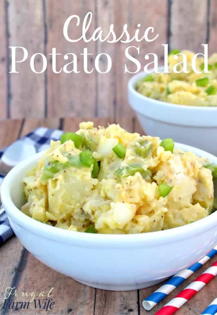 Image shows two bowls of potato salad sitting on a table, with text that reads "Classic Potato Salad"