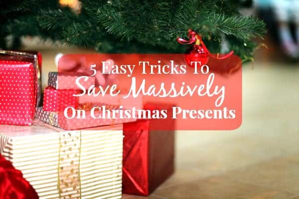 Image shows some wrapped gifts beneath a Christmas tree with text overlay that reads "5 Easy Tricks to Save Massively on Christmas Presents"