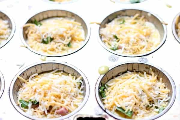 Photo shows the final ingredients added to the pizzas in the muffin tin